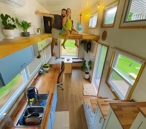 a man and woman are sitting on the top of a tiny house at Experiência única na Toca Turquesa – Natureza e conforto in Santa Isabel +14 photos