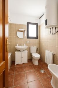 a bathroom with a sink toilet and a mirror at La casita fondonera in Fondón