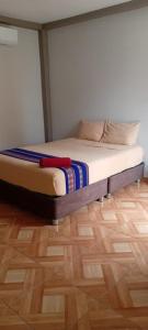 a bed in a room with a wooden floor at Machu Picchu Selva Hotel in Isla Chinería