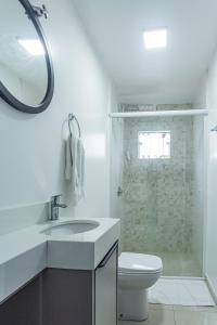 a white bathroom with a sink and a toilet at Apartamento Melhor Localizado em Pomerode in Pomerode +20 photos