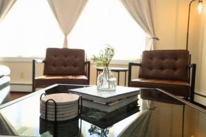 a living room with a glass table and two chairs at Group Chic - 25 Mins to NYC - FREE Parking - Washer & Dryer in Fairview
