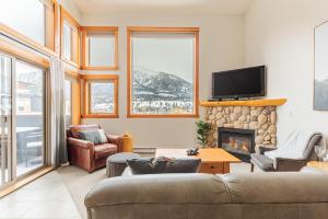 a living room with a couch and a fireplace at Downtown Delight - Penthouse with Shared Rooftop Hot Tub in Canmore