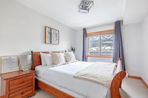 a bedroom with a bed and a window at Downtown Delight - Penthouse with Shared Rooftop Hot Tub in Canmore +57 photos