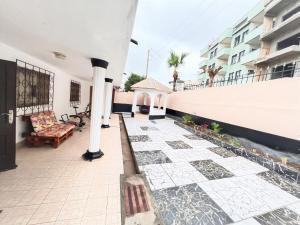 a courtyard of a house with a bench and a chair at The Yafé Bastos 15 (Villa) in Yaoundé +24 photos