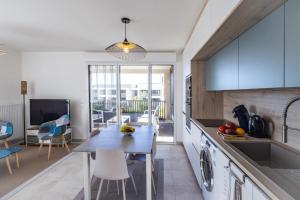 a kitchen and living room with a table and chairs at FLORA -T2 46 m2 - terrasse in Mauguio