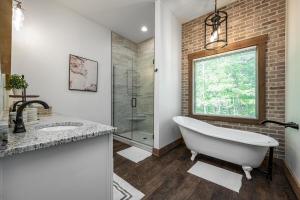 un baño con bañera y ducha de cristal en Fireside Ridge Blue Ridge Luxury cabin, en Blue Ridge 47 fotos más