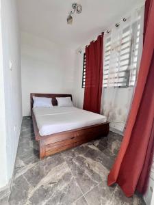 a bed in a room with a red curtain at RoofTop Appart Nouvelle Ville in Toamasina