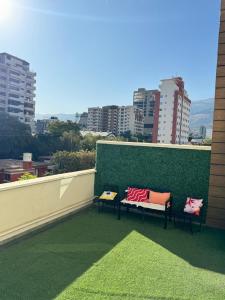 dwie ławki na balkonie z zieloną ścianą w obiekcie Familiar con terraza privada zona norte w mieście Cochabamba