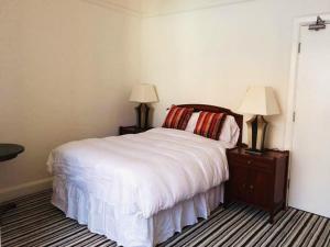een slaapkamer met een wit bed en 2 lampen bij INGRAM ARMS HOTEL, HATFIELD in Doncaster