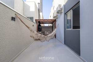 a hammock on the balcony of a building at Apto c/ Churrasqueira a 230 m da Praia SHA0104 in Piçarras