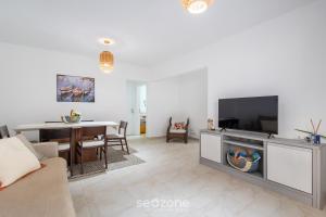 a living room with a couch and a tv and a table at Apto c/ Churrasqueira a 230 m da Praia SHA0104 in Piçarras