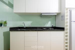 a kitchen with white cabinets and a sink at Apto c/ Churrasqueira a 230 m da Praia SHA0104 in Piçarras +17 photos