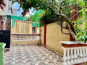 a patio with a fence and a tree next to a building at Étage de villa Elkala in El Kala