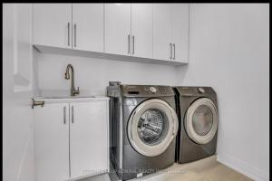 a kitchen with a washing machine and a sink at Entire place in Richmond hill Modern Luxury Home in Richmond Hill