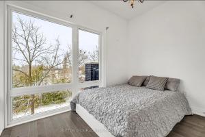 a bedroom with a bed and a large window at Entire place in Richmond hill Modern Luxury Home in Richmond Hill