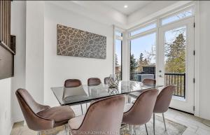 a dining room with a glass table and chairs at Entire place in Richmond hill Modern Luxury Home in Richmond Hill