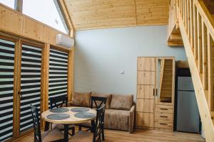 a room with a table and chairs and a couch at Domki nad Wiarem in Huwniki