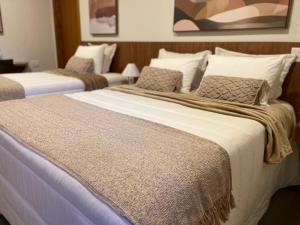 ein paar Betten in einem Zimmer mit in der Unterkunft Keko Hotel in Guapiaçu