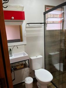 une salle de bain avec toilettes, lavabo et douche dans l'établissement Chalé Santo Antônio do Pinhal, à Santo Antônio do Pinhal