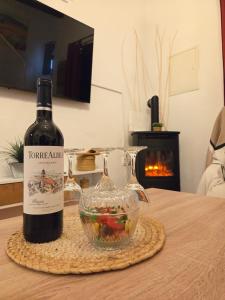 una botella de vino y un bol de fruta en una mesa en Casa Rural El Refugio, en Zuheros