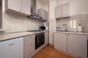 a kitchen with white cabinets and a sink at Apartman Stella in Vodnjan