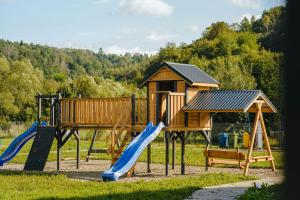 a playground with a slide and a house at Domki nad Wiarem in Huwniki