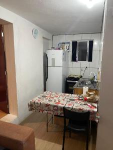 een kleine keuken met een tafel en een koelkast bij Casa Kekel in Florianópolis