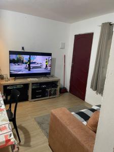 een woonkamer met een flatscreen-tv en een bank bij Casa Kekel in Florianópolis