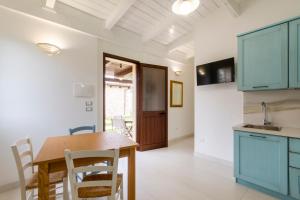 a kitchen with blue cabinets and a wooden table at Agriturismo il Contadino in Otranto