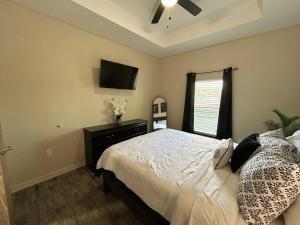 a bedroom with a bed and a ceiling fan at Quiet 2BR Retreat , Fenced yard , Modern Duplex in Harlingen