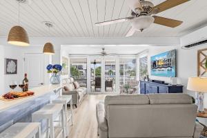 a living room with a couch and a ceiling fan at Boating Enthusiasts, Walk to the Beach, Heated Pool - The Corner cottage - Roelens in Fort Myers Beach