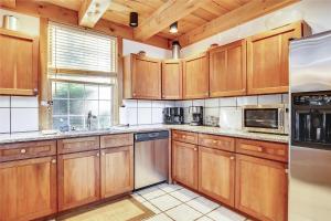 a large kitchen with wooden cabinets and a window at Redwood in Stowe Fork