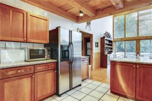 a kitchen with wooden cabinets and a stainless steel refrigerator at Redwood in Stowe Fork +32 photos