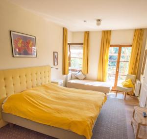 a bedroom with a yellow bed and a couch at Ferienwohnung Villa 16F in Pirna