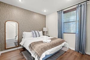 una camera da letto con un letto grande e uno specchio di Designer 3BR El Monte Retreat Near DTLA & Pasadena a Hayes Altre 71 foto