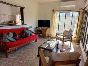 a living room with a red couch and a tv at Casa con vista al mar para 7 personas a 50 metros de la Playa!! in San Luis