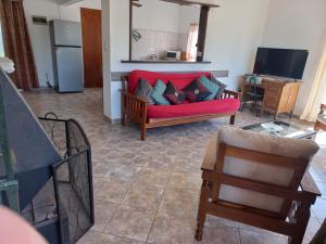 a living room with a red couch and a kitchen at Casa con vista al mar para 7 personas a 50 metros de la Playa!! in San Luis