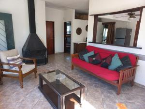 a living room with a red couch and a fireplace at Casa con vista al mar para 7 personas a 50 metros de la Playa!! in San Luis