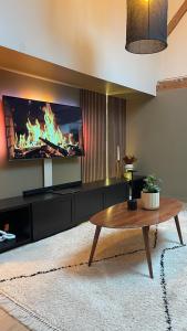 a living room with a table and a fireplace at A la Petite Grange in Obenheim