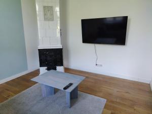 a living room with a table and a flat screen tv at Zentrale Altbau FEWO 2 in Flensburg
