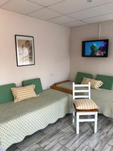 a room with two twin beds and a chair at Las Heras in Olavarría