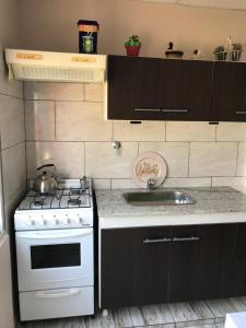 a kitchen with a stove and a sink at Las Heras in Olavarría