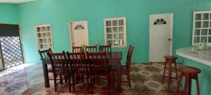a dining room with green walls and a table and chairs at Rancho Carmen in El Garitón