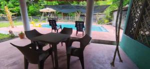 a patio with a table and chairs and a pool at Rancho Carmen in El Garitón