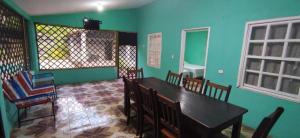 a dining room with green walls and a table and chairs at Rancho Carmen in El Garitón +2 photos