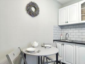 une cuisine blanche avec une table et des chaises blanches dans l'établissement Арбат в Золотом квадрате двухкомнатная стильная в центре 25, à Almaty 22 autres photos