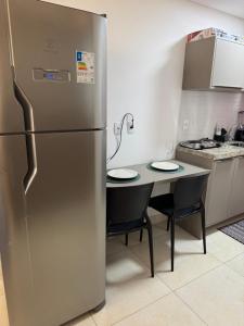 a stainless steel refrigerator in a kitchen with a table at FLAT MANAIRA APART HOTEl in João Pessoa +8 photos