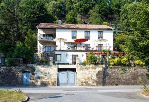a large white house with a stone wall at Ferienwohnung Villa 16F in Pirna
