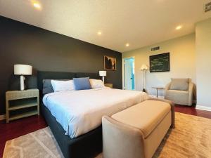 a bedroom with a large bed and a chair at Spacious 4B2B HOUSE DTLA & Disney Office Gym in Hacienda Heights