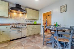 a kitchen with yellow cabinets and a table with chairs at Valentine Cottage in Snape +11 photos